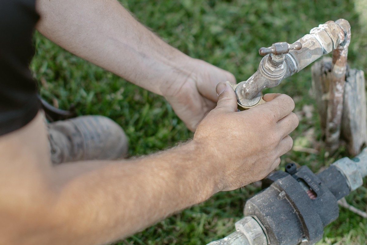 Plumber working on a tap and water meter assembly