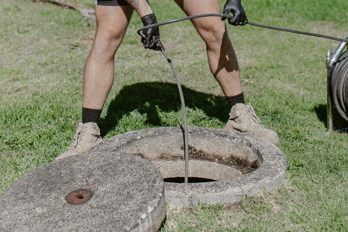 Open sewer inspection shaft with a jetting hose feeding in